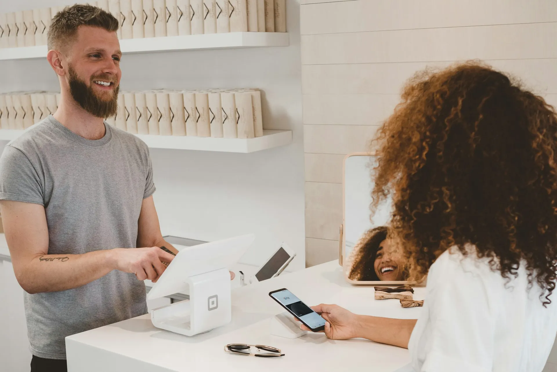 A smiling local shop owner greeting a customer
